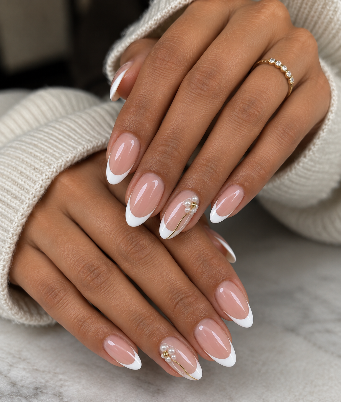 Almond French tip press-on nails with a pearl and gold charm accent nail