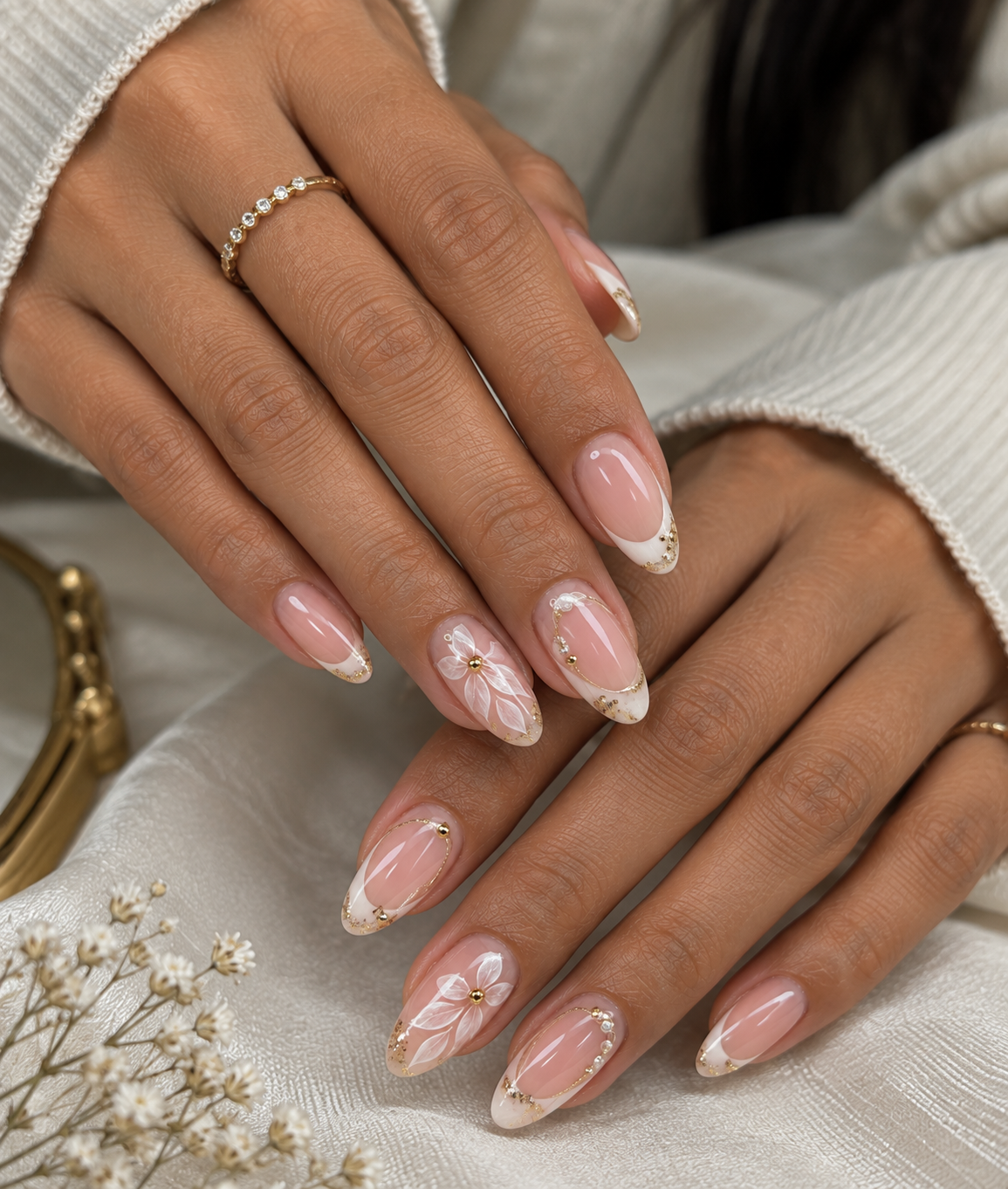 Almond French tip press-on nails with gold trim and hand-painted floral accent