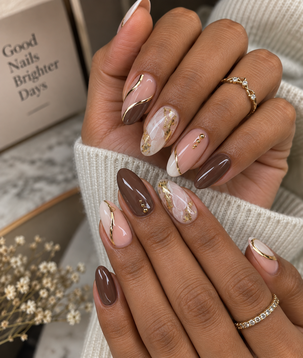 Mocha brown and nude press-on nails with gold swirl accents and marbled gold-foil nail art